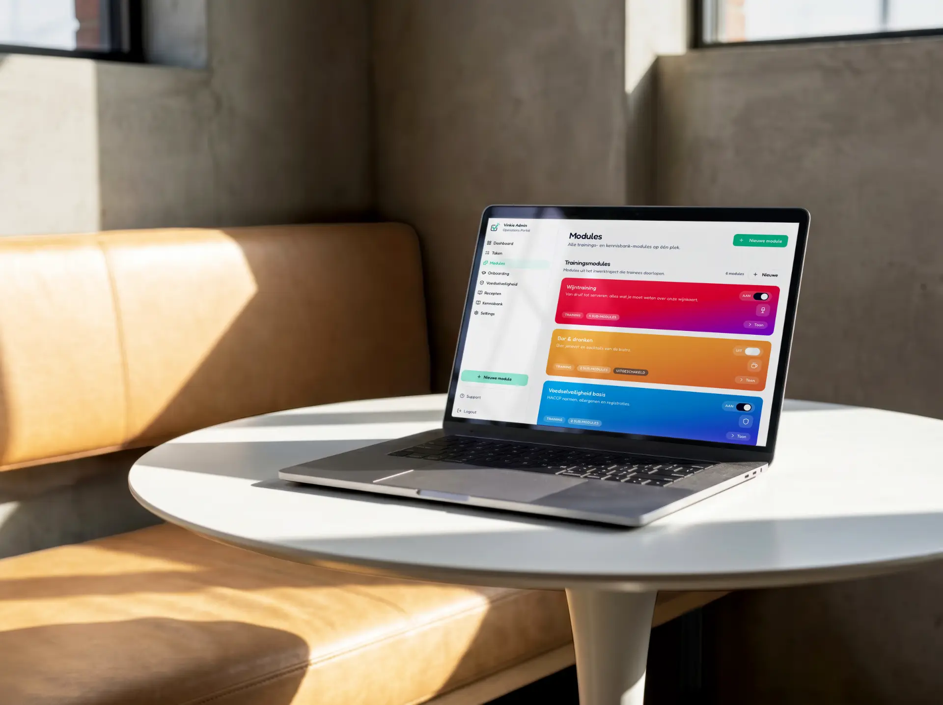 Een laptop op een tafeltje in de zaak met het Vinkie-moduleoverzicht: trainingsmodules zoals wijntraining, bar en dranken en voedselveiligheid basis